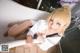 A woman in a white shirt is sitting in a bathtub.