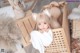 A woman laying in a wooden crate with a cat ears headband.