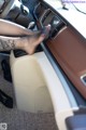 A woman with a tattoo on her leg sitting in a car.