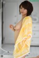 A woman in a yellow and white checkered kimono posing naked.