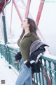 A woman standing on a bridge in the snow.