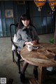 A woman sitting at a table with a cup of coffee.