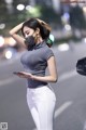 A woman wearing a face mask standing on a city street.