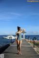 A woman in a bathing suit standing on a pier.