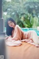 A woman laying on a bed next to a swimming pool.