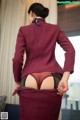 A woman in a red suit is showing off her panties.