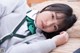 A young woman laying on a bed wearing a green bow tie.