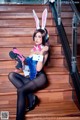 A woman in a bunny costume holding a gun.