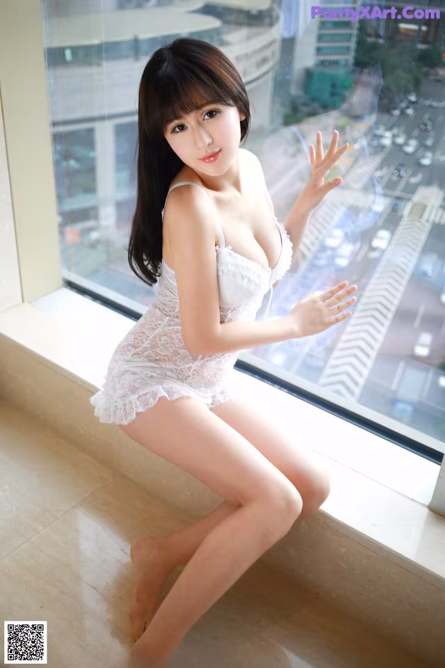 A woman in a white lingerie sitting on a window sill.