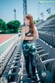 A woman standing in a stadium with her back to the camera.