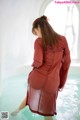 A woman in a red dress standing in a pool.