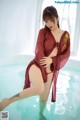 A woman in a red robe is standing in a pool.