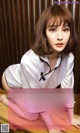 A woman sitting on top of a wooden table.