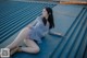 A woman sitting on top of a blue metal roof.