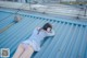 A woman laying on top of a metal roof.