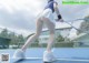 A woman is playing tennis on a blue court.