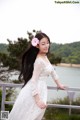 A woman in a white dress with a flower in her hair.