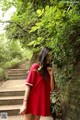 A woman in a red dress smoking a cigarette.