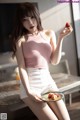 A woman sitting on a table holding a plate of strawberries.